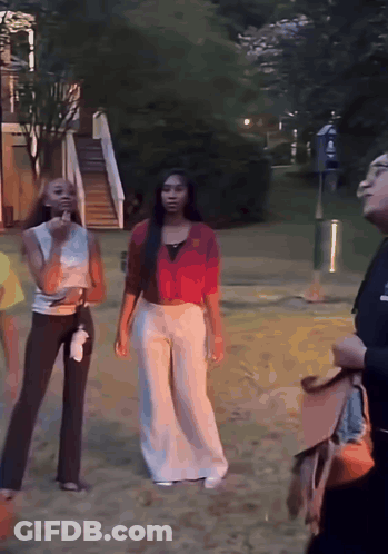 Woman In Red Shirt Standing Next To Another Woman GIF