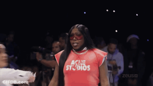 Woman In Red Shirt With Studios Walking Down Runway GIF