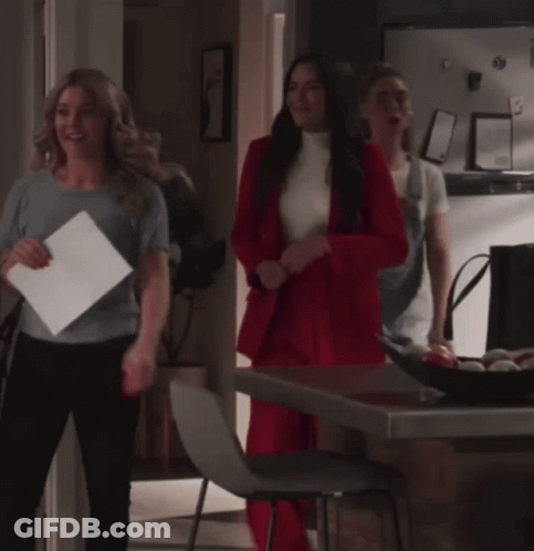 Woman In Red Suit Standing Next To Woman GIF