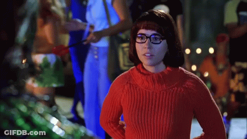 Woman In Red Sweater And Glasses Standing Before Group GIF