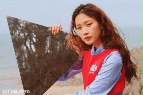 Woman In Red Sweater Holding Triangle In Front Of Face GIF