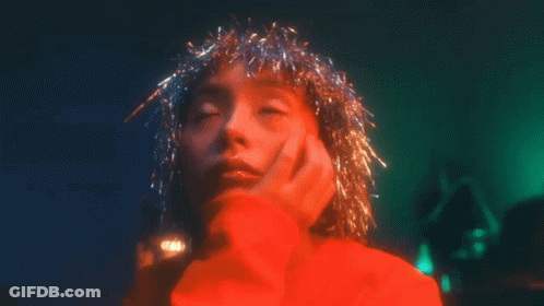 Woman In Red Sweater With Tinsel On Head GIF