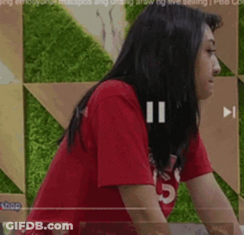 Woman In Red T-Shirt In Front Of Green Wall GIF