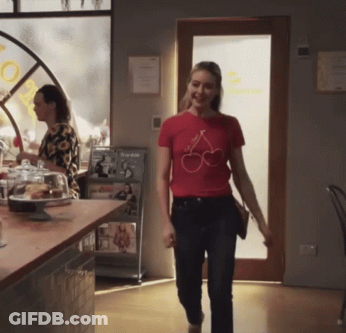 Woman In Red T-Shirt With Cherries Walking Through Restaurant GIF