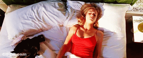 Woman In Red Tank Top Laying On White Bed GIF