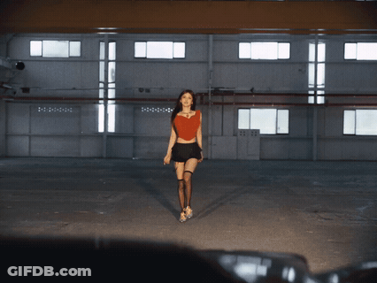 Woman In Red Top And Black Skirt Walking In Dark Room GIF