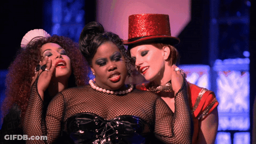 Woman In Red Top Hat Surrounded By Two Women GIF