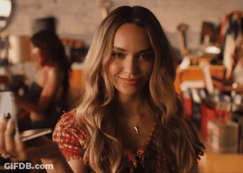 Woman In Red Top Smiling And Holding Cellphone GIF