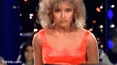Woman In Red Top Standing In Front Of RTL HD TV Screen GIF