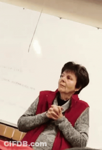 Woman In Red Vest Sitting In Front Of Whiteboard GIF