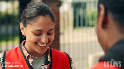 Woman In Red Vest Smiling And Talking GIF