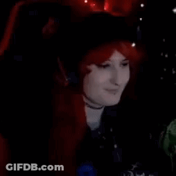 Woman In Red Wig And Headphones Sitting In Chair GIF