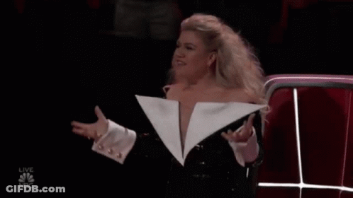Woman In Revealing White Jacket At Microphone GIF