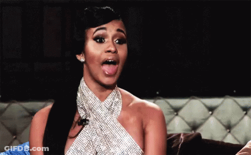 Woman In Rhinestone Dress Sticking Tongue Out On Couch GIF