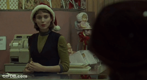 Woman In Santa Hat Behind Counter GIF