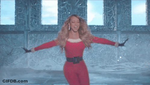 Woman In Santa Outfit Dancing In Front Of Window GIF