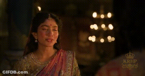 Woman In Sari Standing In Front Of Window With Lights GIF