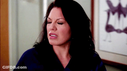 Woman In Scrub Top Making Funny Face In Front Of Picture GIF