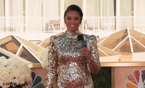 Woman In Sequined Dress By Golden Globe Sign GIF