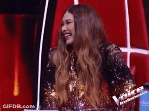 Woman In Sequined Dress Laughing On Red Chair GIF