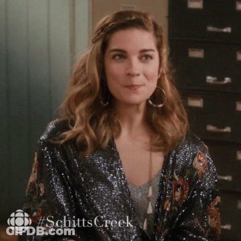 Woman In Sequined Jacket And Hoop Earrings From Schitts Creek GIF
