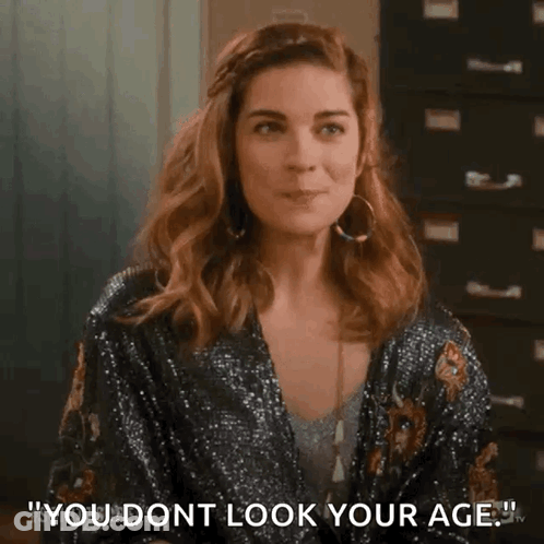 Woman In Sequined Jacket Saying You Don't Look Your Age GIF