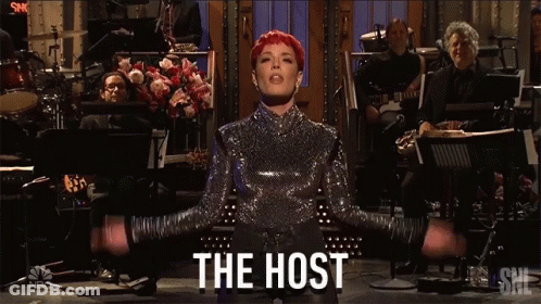 Woman In Sequined Top In Front Of Orchestra The Host GIF
