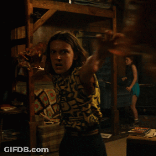 Woman In Shirt Saying A In Dark Room GIF
