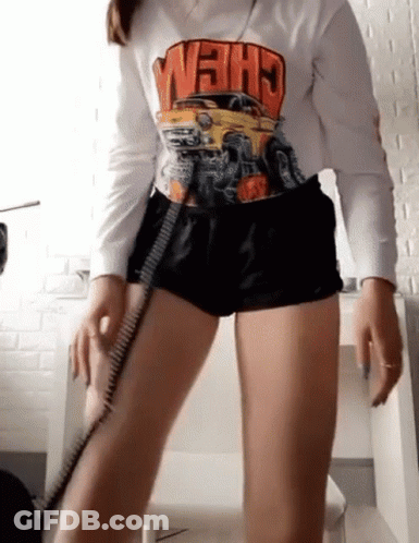 Woman In Shorts And Crew Shirt Standing At Desk GIF