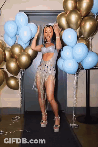 Woman In Silver Dress Dancing In Front Of Balloons GIF