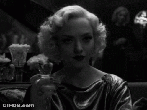 Woman In Silver Dress Holding Wine GIF