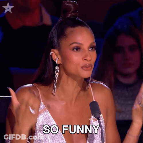 Woman In Silver Dress Says So Funny At Microphone GIF