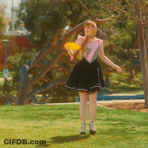 Woman In Skirt Holding Frisbee GIF