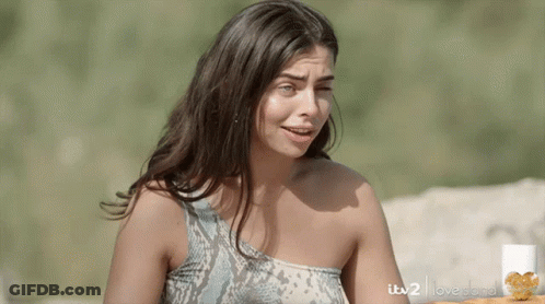 Woman In Snake Print Top In Front Of ITV2 Love Island Sign GIF