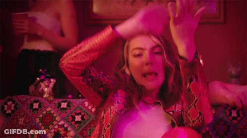 Woman In Snakeskin Jacket Laying On Couch GIF