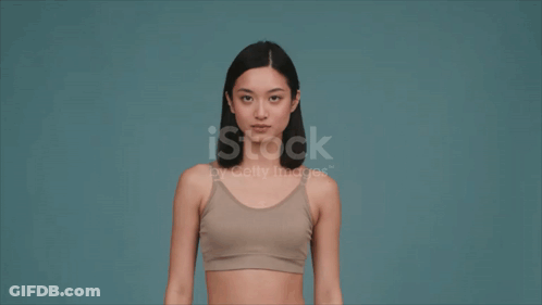 Woman In Sports Bra Flexing Muscles GIF