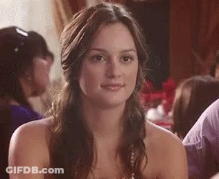 Woman In Strapless Dress Smiling At Table GIF