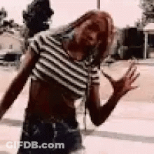 Woman In Striped Crop Top Standing On Sidewalk GIF