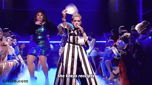 Woman In Striped Dress Holding Fan Singing Into Microphone GIF