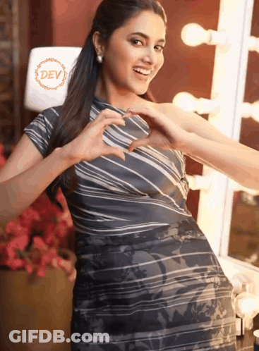 Woman In Striped Dress Making Heart With Hands In Front Of Dev Logo GIF