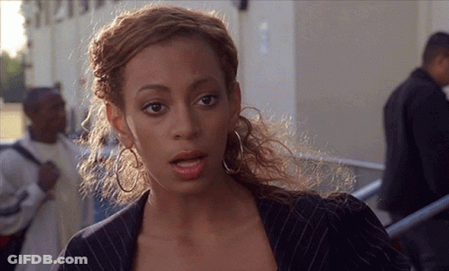 Woman In Striped Jacket And Hoop Earrings In Front Of Building 1212 GIF