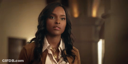 Woman In Striped Shirt And Brown Jacket Looking At Camera GIF