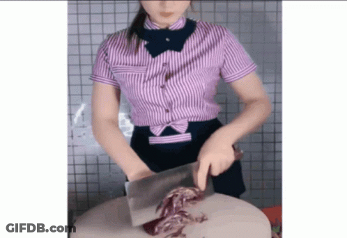 Woman In Striped Shirt Cutting Piece Of Meat GIF