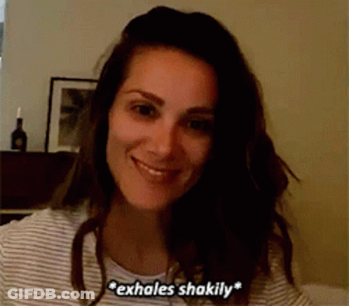 Woman In Striped Shirt Smiling And Exhaling Shakily GIF