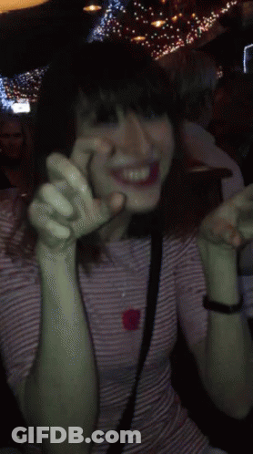 Woman In Striped Shirt Smiling With Hands Up GIF