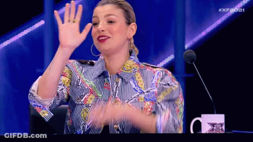 Woman In Striped Shirt Waving At Microphone GIF