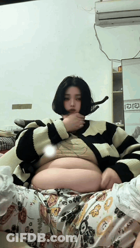 Woman In Striped Sweater Laying On Bed GIF