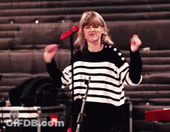Woman In Striped Sweater Singing Into Microphone GIF