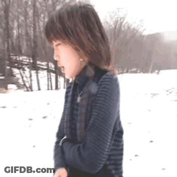 Woman In Striped Sweater Standing In Snow GIF