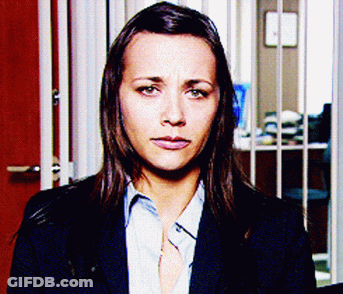 Woman In Suit And Blue Shirt Looking At Camera GIF